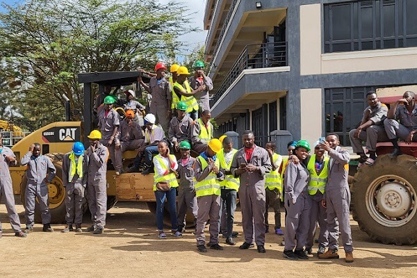 International Plant Machinery Technical Training Institute students outside lecture rooms with excavators 